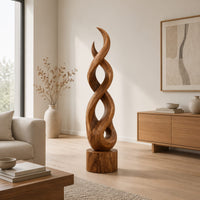 Twisted wood sculpture of intertwined ribbons on a short cylinder base in a Scandinavian living room with white walls