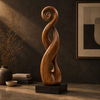 Twisted ribbon sculpture with open loops, a spiral top and a dark base, three-quarter view showing the grain