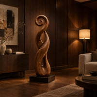 Twisted ribbon sculpture with open loops, a spiral top and a dark base in an evening living room with walnut wall paneling