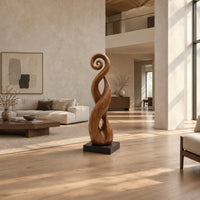 Twisted ribbon sculpture with open loops, a spiral top and a dark base in a bright open plan living room