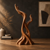Twisted root style sculpture with an open hollow and two flame shaped tips in a dark studio against a charcoal plaster wall