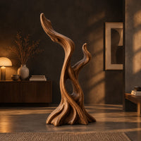 Twisted root style sculpture with an open hollow and two flame shaped tips in a dark living room at golden hour