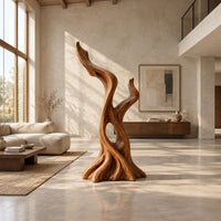 Twisted root style sculpture with an open hollow and two flame shaped tips in a bright open plan living room