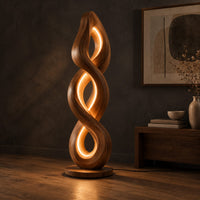 Twisted spiral floor lamp with three glowing loops on a disc base, three-quarter view showing the grain