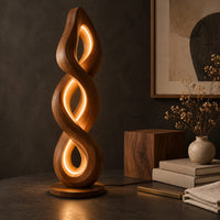 Corner detail of twisted spiral floor lamp with three glowing loops on a disc base beside wood, brass and linen samples