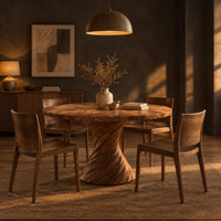 Circular dining table with a twisted spiral hourglass pedestal in a dark dining room at golden hour