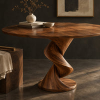Corner detail of round dining table with a twisting spiral pedestal on a circular foot beside wood, brass and linen samples