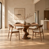 Round dining table with a twisting spiral pedestal on a circular foot in a bright open plan dining room