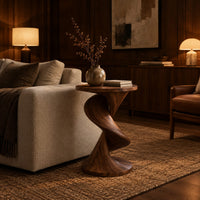 Round side table with a twisting spiral pedestal and a flared base in an evening living room with walnut wall paneling