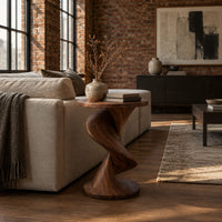 Round side table with a twisting spiral pedestal and a flared base in an industrial loft living room with exposed brick