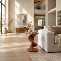 Round side table with a twisting spiral pedestal and a flared base in a bright open plan living room