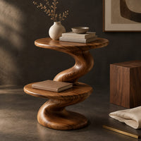 Corner detail of side table with a spiral twisted stem and two round tiers beside wood, brass and linen samples