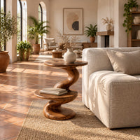 Side table with a spiral twisted stem and two round tiers in a bright living room with arched windows and plants