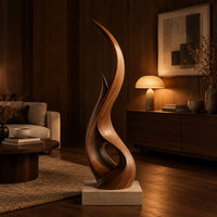 Tall twisting flame shaped wood sculpture with an open loop near the base in an evening living room with walnut wall paneling
