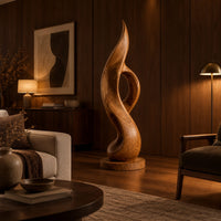 Tall twisting flame sculpture with an open loop on a flat disc base in an evening living room with walnut wall paneling