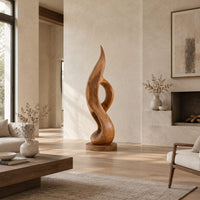 Tall twisting flame sculpture with an open loop on a flat disc base in a bright open plan living room