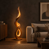 Twisting ribbon floor lamp with warm glow inside its loops in a dark living room at golden hour