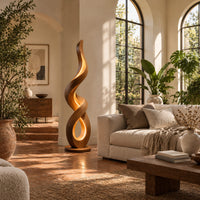 Twisting ribbon floor lamp with warm glow inside its loops in a bright living room with arched windows and plants