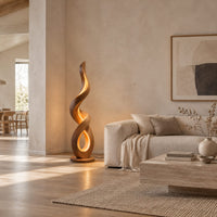 Twisting ribbon floor lamp with warm glow inside its loops in a bright open plan living room