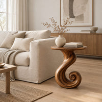 Round side table on a ribbon pedestal that ends in a spiral curl in a Scandinavian living room with white walls