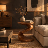 Twisting s shape side table with a circular top and wide disc base in a dark living room at golden hour