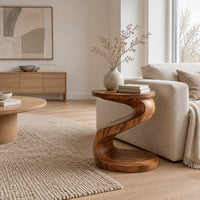 Twisting s shape side table with a circular top and wide disc base in a Scandinavian living room with white walls
