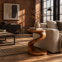Twisting s shape side table with a circular top and wide disc base in an industrial loft living room with exposed brick