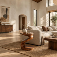 Twisting s shape side table with a circular top and wide disc base in a bright open plan living room