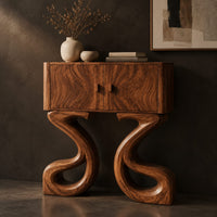 Corner detail of two door console cabinet on large looping ribbon shaped legs beside wood, brass and linen samples