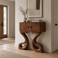 Two door console cabinet on large looping ribbon shaped legs in a Scandinavian entryway with white walls