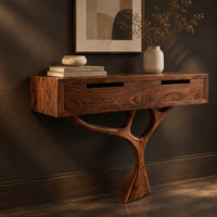 Corner detail of console table with a two drawer box on a single branching tree pedestal beside wood, brass and linen samples
