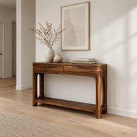 Console table with a two panel front rail and a low open shelf in a Scandinavian entryway with white walls