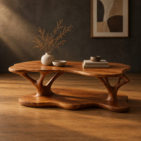 Two tier coffee table with a freeform top and branch shaped supports in a dark studio against a charcoal plaster wall