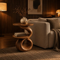 Two tier end table with a spiral ribbon base and a loop foot in an evening living room with walnut wall paneling