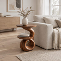 Two tier end table with a spiral ribbon base and a loop foot in a Scandinavian living room with white walls