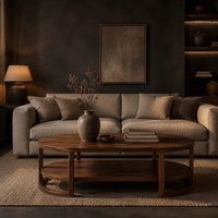 Two tier oval wooden coffee table with slim legs and half ring supports in a dark living room at golden hour
