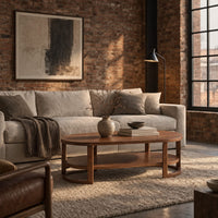 Two tier oval wooden coffee table with slim legs and half ring supports in an industrial loft living room with exposed brick