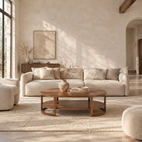 Two tier oval wooden coffee table with slim legs and half ring supports in a bright open plan living room