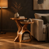 Two tier side table with a trunk base and a hollow for books in a dark living room at golden hour