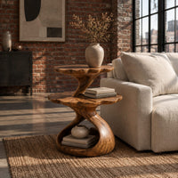 Two tier side table with scalloped tops and a twisting stem in an industrial loft living room with exposed brick