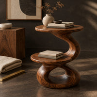 Corner detail of two tier side table with a twisted stem and a figure eight base beside wood, brass and linen samples