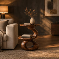 Two tier side table with a twisted stem and a figure eight base in a dark living room at golden hour