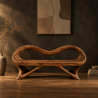 Wooden bench with a wavy looped rim and slender splayed legs in a dark studio against a charcoal plaster wall