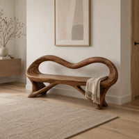 Wooden bench with a wavy looped rim and slender splayed legs in a Scandinavian entryway with white walls