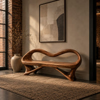 Wooden bench with a wavy looped rim and slender splayed legs in an industrial loft entryway with exposed brick