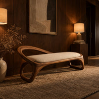 Bench with a padded seat and an arched back rail on open loop legs in an evening entryway with walnut wall paneling
