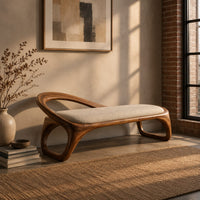 Bench with a padded seat and an arched back rail on open loop legs in an industrial loft entryway with exposed brick