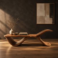 Bench with a flat plank seat, a swooping base and an upswept tail in a dark studio against a charcoal plaster wall