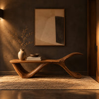 Bench with a flat plank seat, a swooping base and an upswept tail in a dark entryway at golden hour