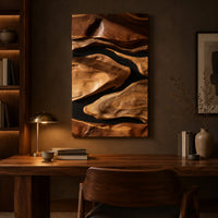Vertical carved wall art with flowing forms on a dark ground above a desk in a dark study corner